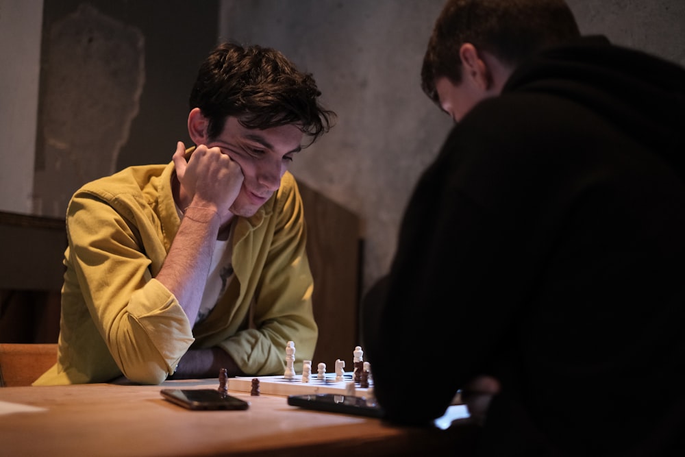 a man sitting at a table playing a game of chess