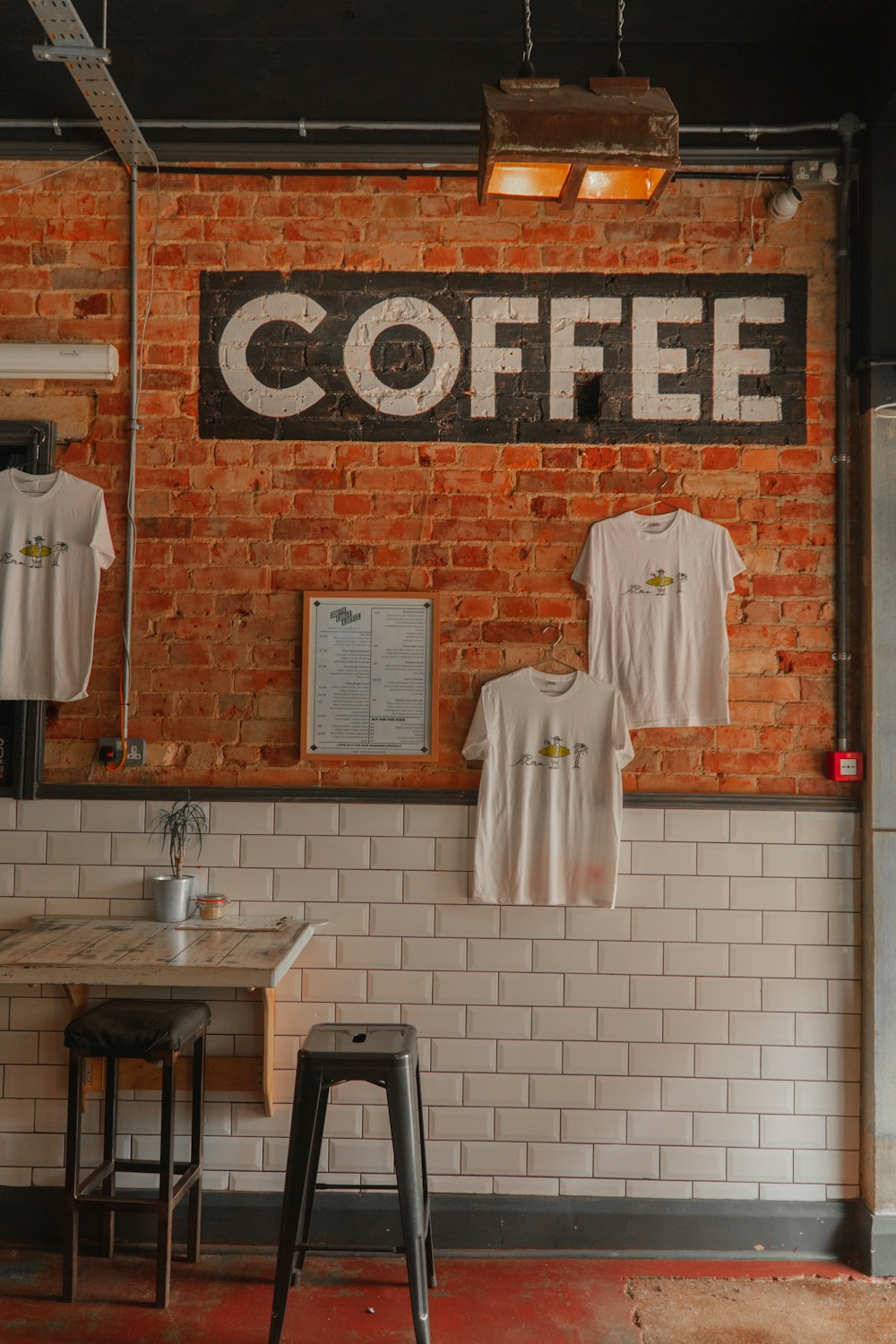 eine Ziegelmauer mit einem Schild mit der Aufschrift "Kaffee"