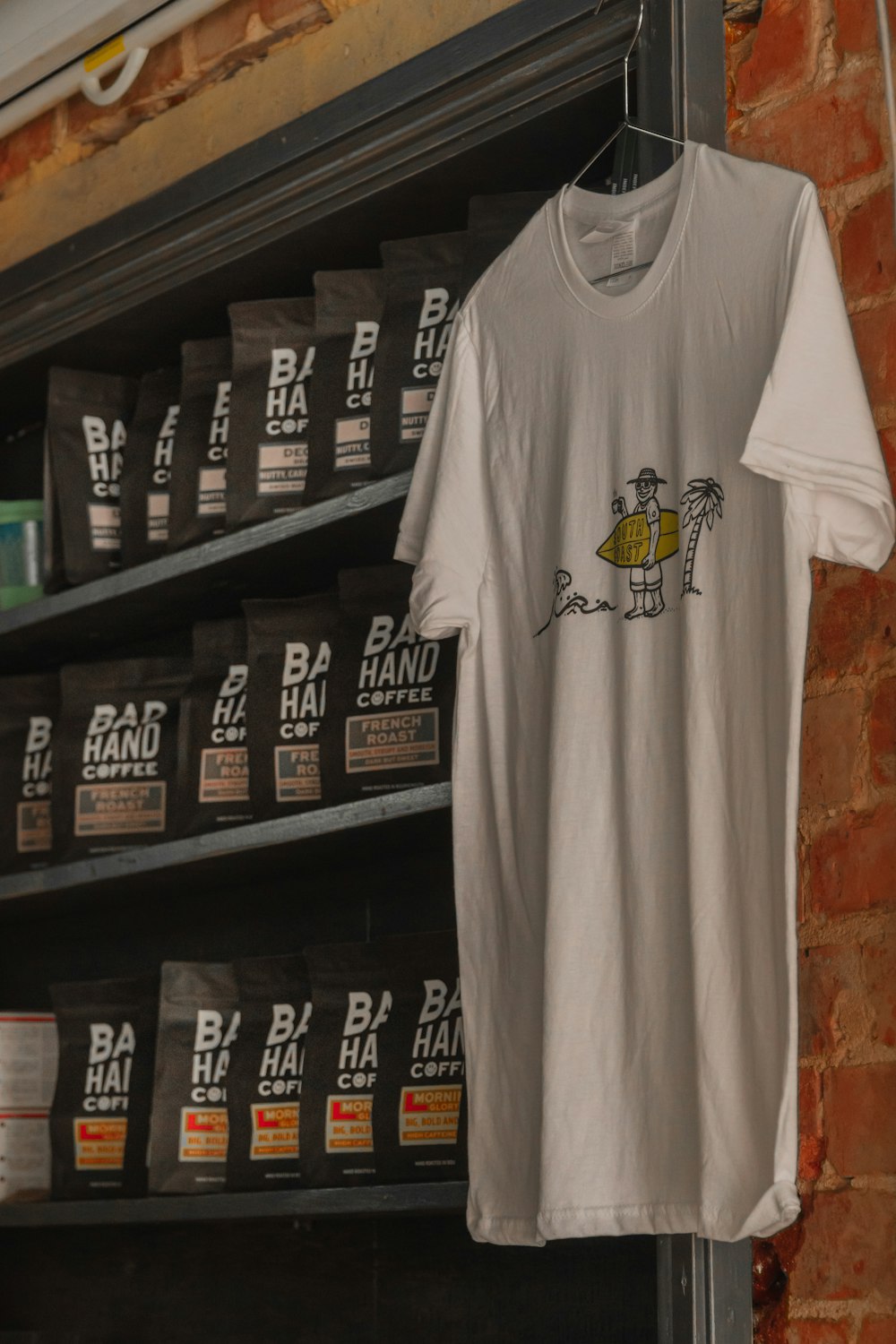 a t - shirt hanging on a rack in a coffee shop