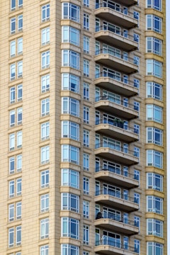 Close-up of modern apartment building exterior with large windows and balconies.