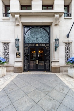 the entrance to a building with blue flowers in front of it