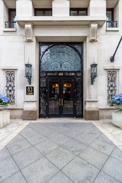 the entrance to a building with blue flowers in front of it