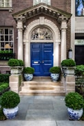Close-up of elegant building entrance featuring polished navy blue doors.