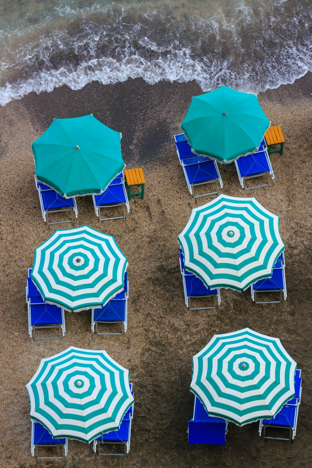 a group of lawn chairs and umbrellas on a beach