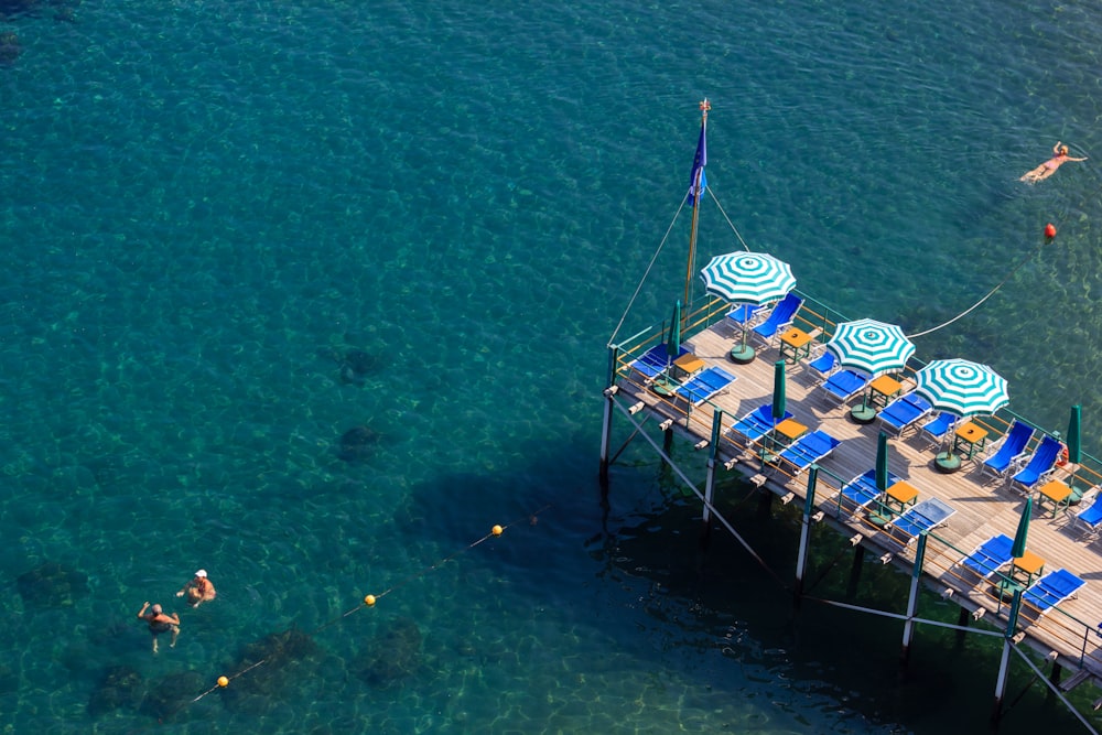 a pier that has chairs and umbrellas on it