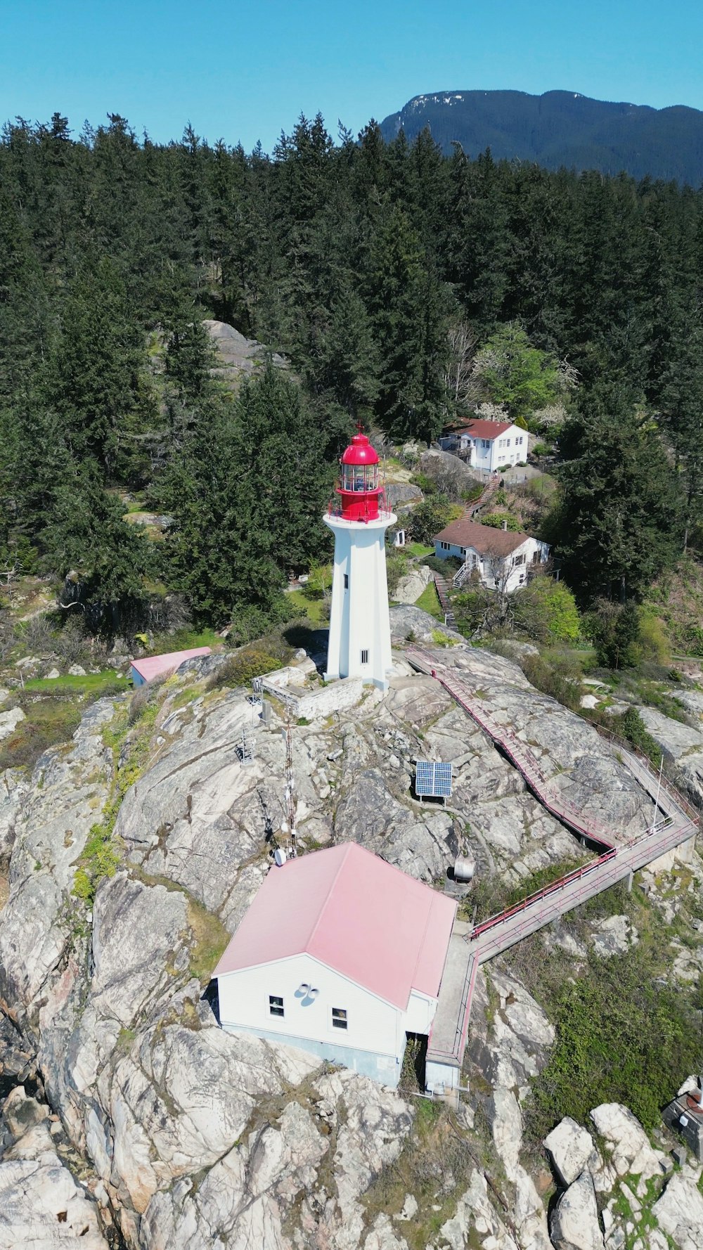 a lighthouse on top of a mountain surrounded by trees