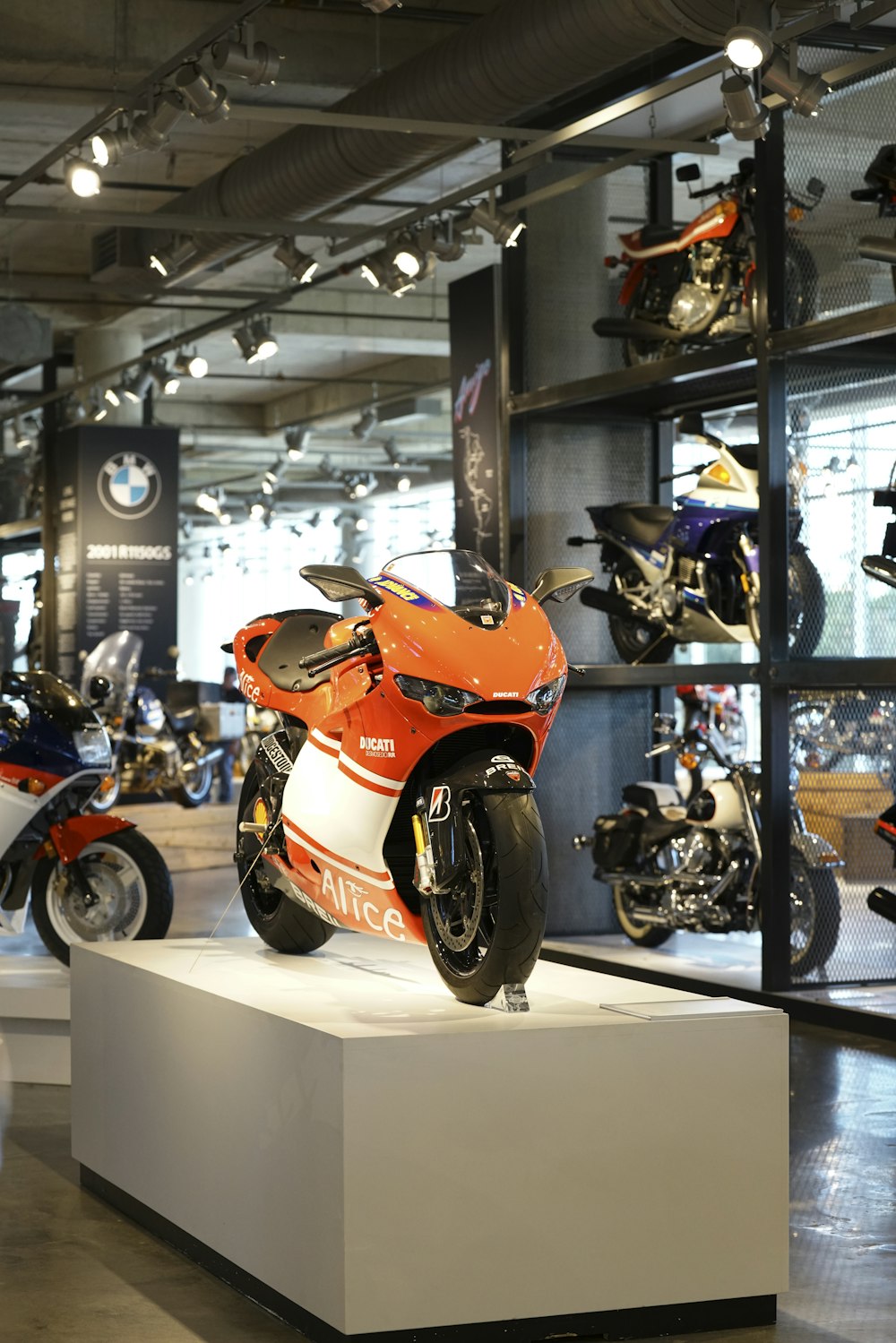 Ein orangefarbenes Motorrad ist in einem Showroom ausgestellt