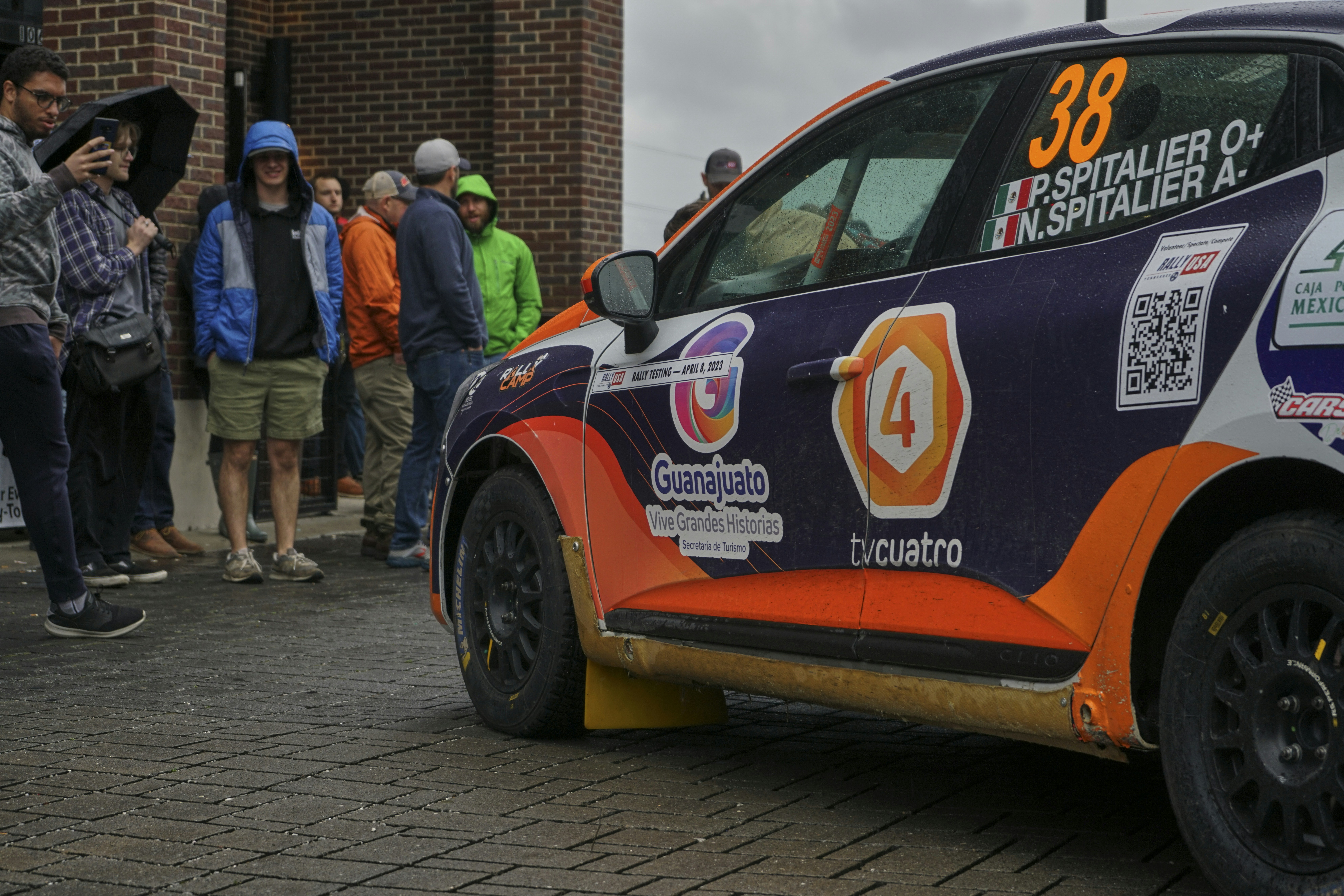 a group of people standing around a car