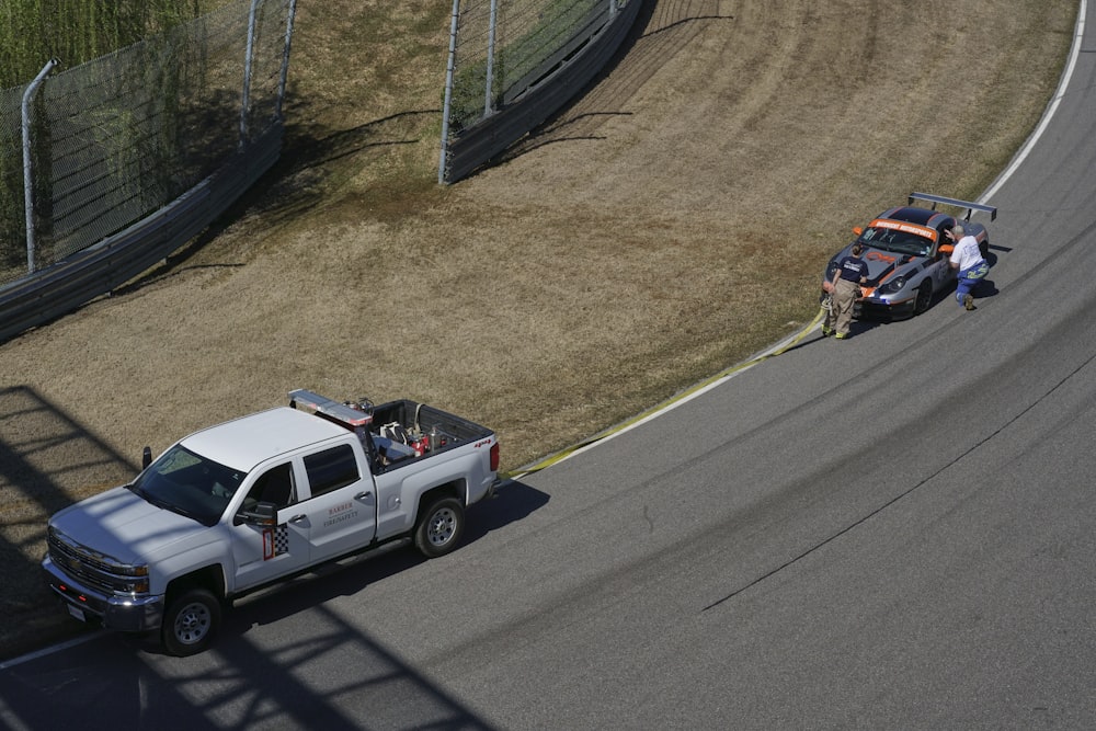 a white truck driving down a race track