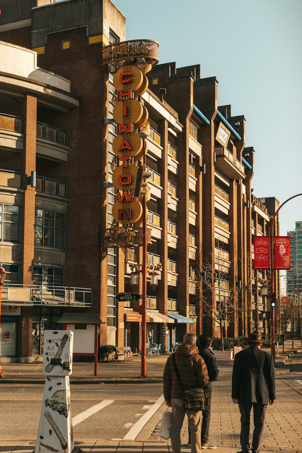 a group of people walking down a street next to a tall building