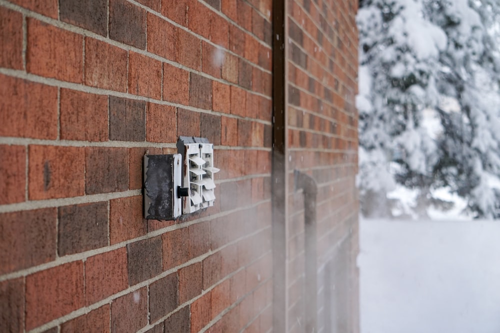 a brick wall with a light switch on it