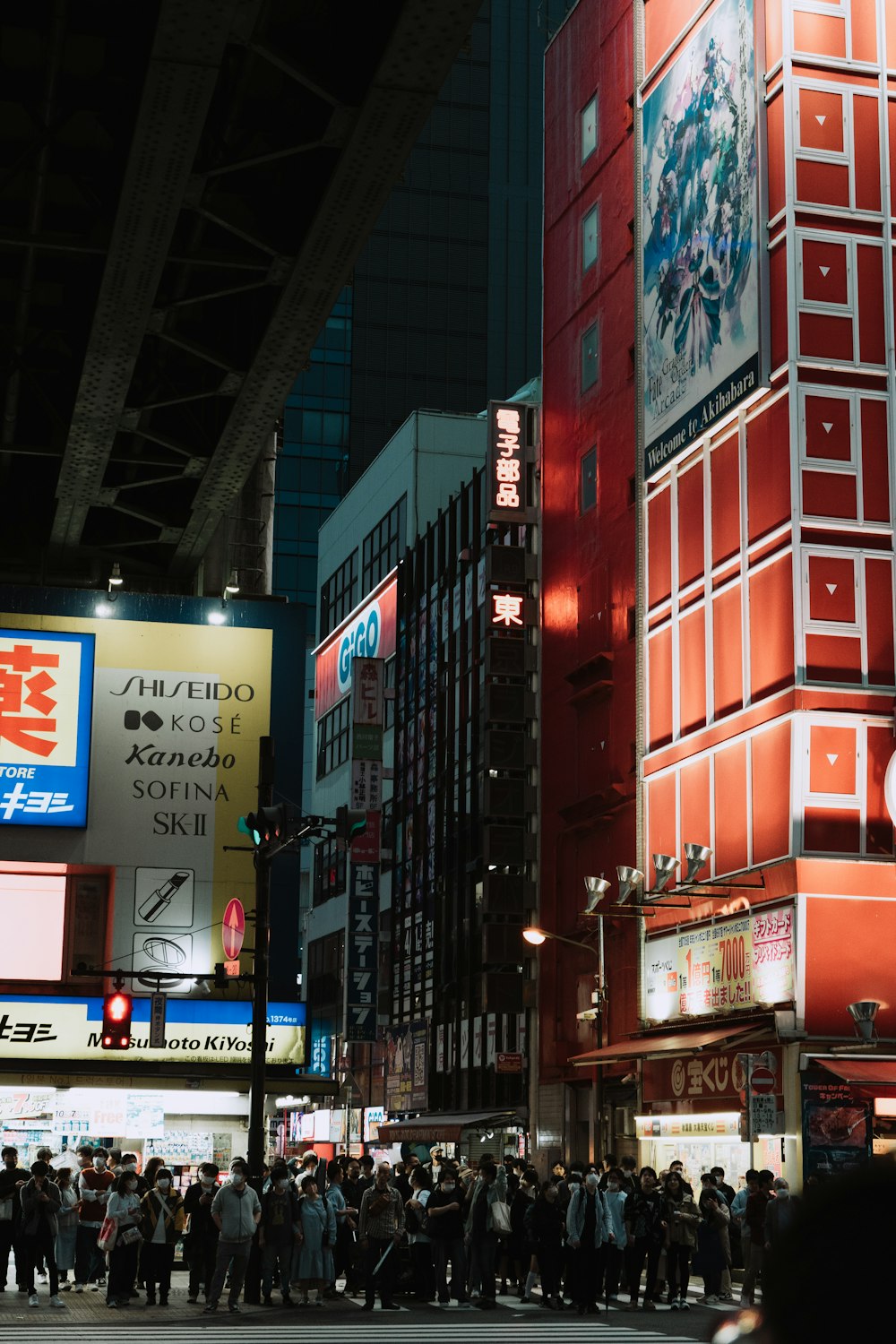 a crowd of people standing on a street next to tall buildings