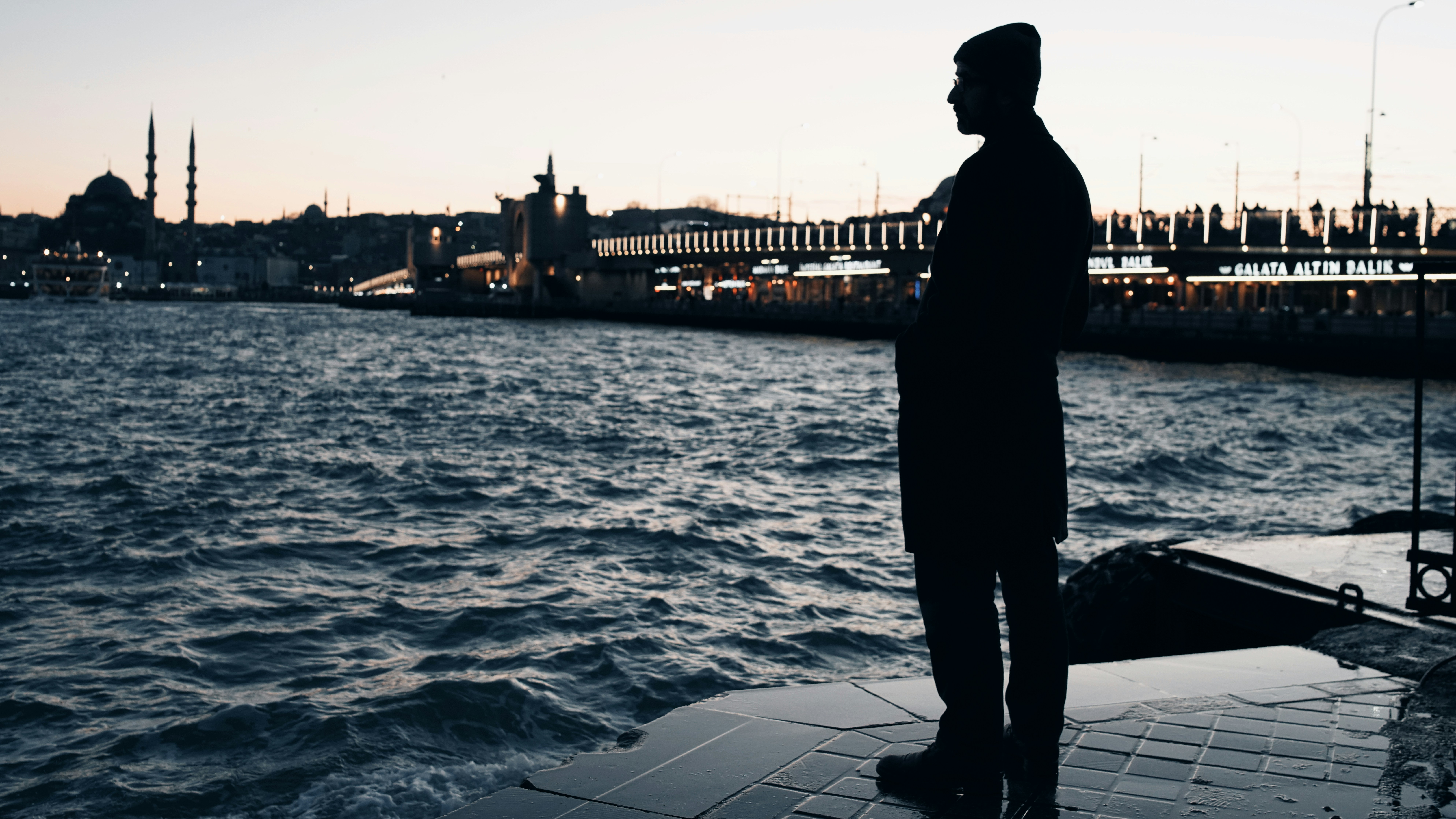 a man standing next to a body of water