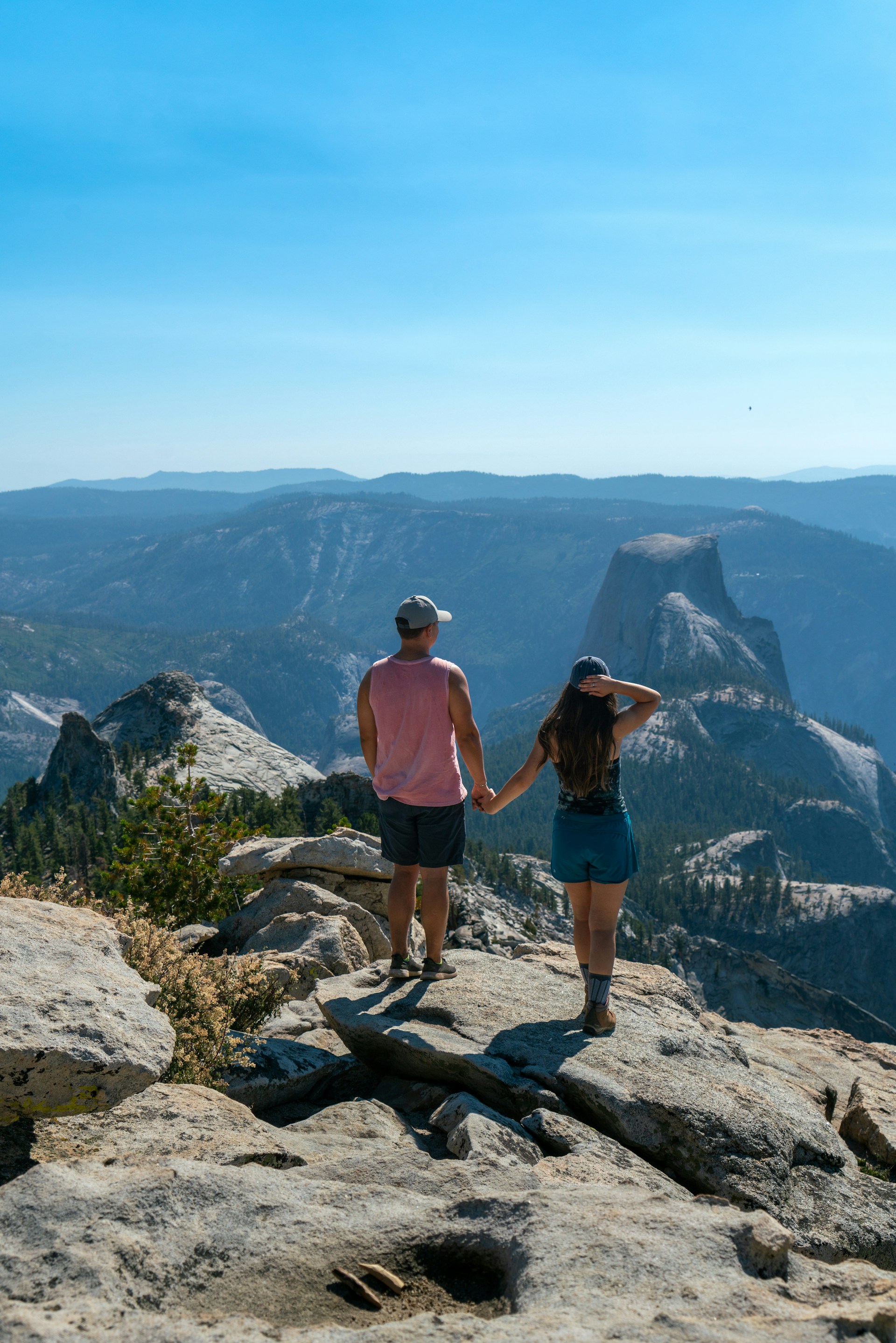 a man and a woman standing on top of a mountain