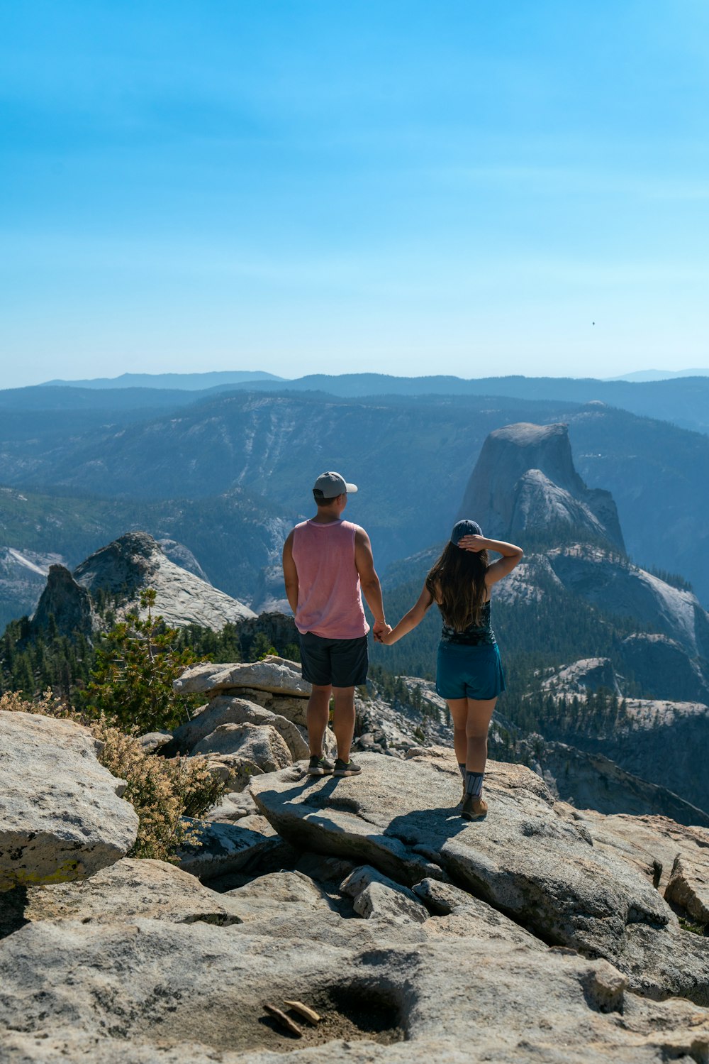 a man and a woman standing on top of a mountain