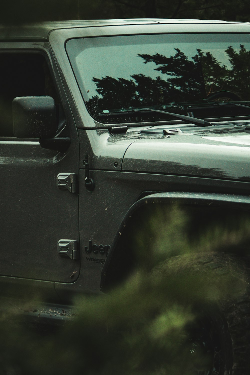 a black jeep parked in a wooded area