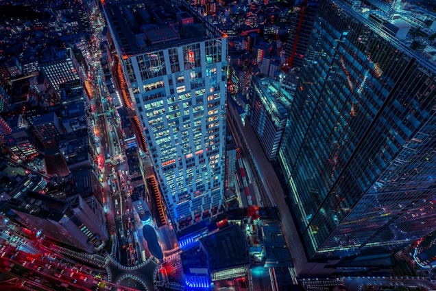 A vibrant aerial shot of a neon-lit digital cityscape glowing under a night sky, alive with motion and color.