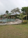 A serene outdoor pool surrounded by lush greenery.