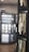 A display of flooring samples is presented on black boards, showcasing a variety of tile and stone options. The samples are organized in straight lines and include different textures and colors such as beige, white, and brown. The foreground focuses on these samples under the company brand Shaw Floors, while a blurred background suggests more displays in a showroom setting.