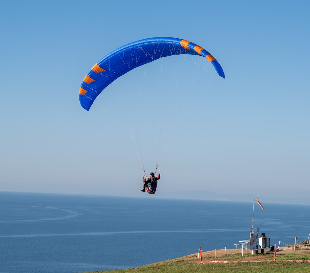 a man is parasailing over the ocean on a clear day