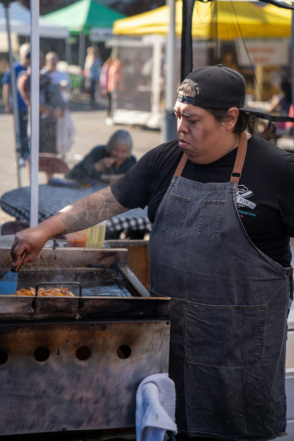 a person cooking food on a grill outside