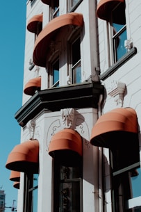 a tall building with orange awnings on the side of it