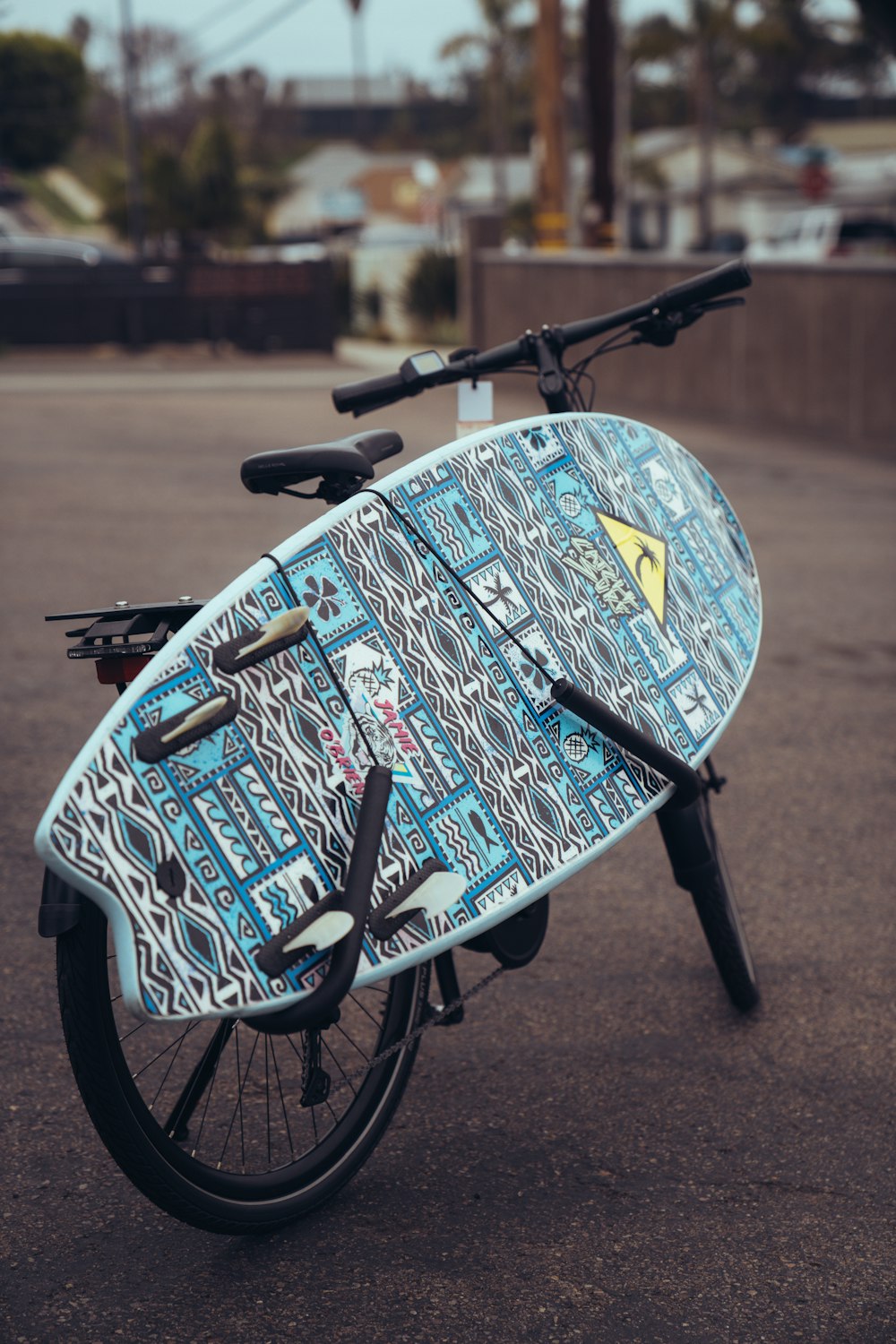 a surfboard strapped to the back of a bicycle