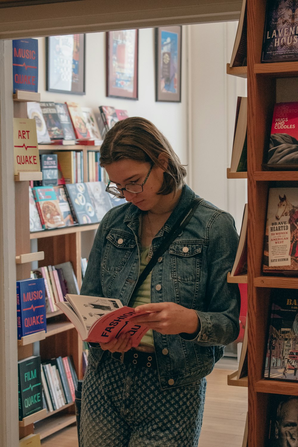 a woman reading a book in a bookstore