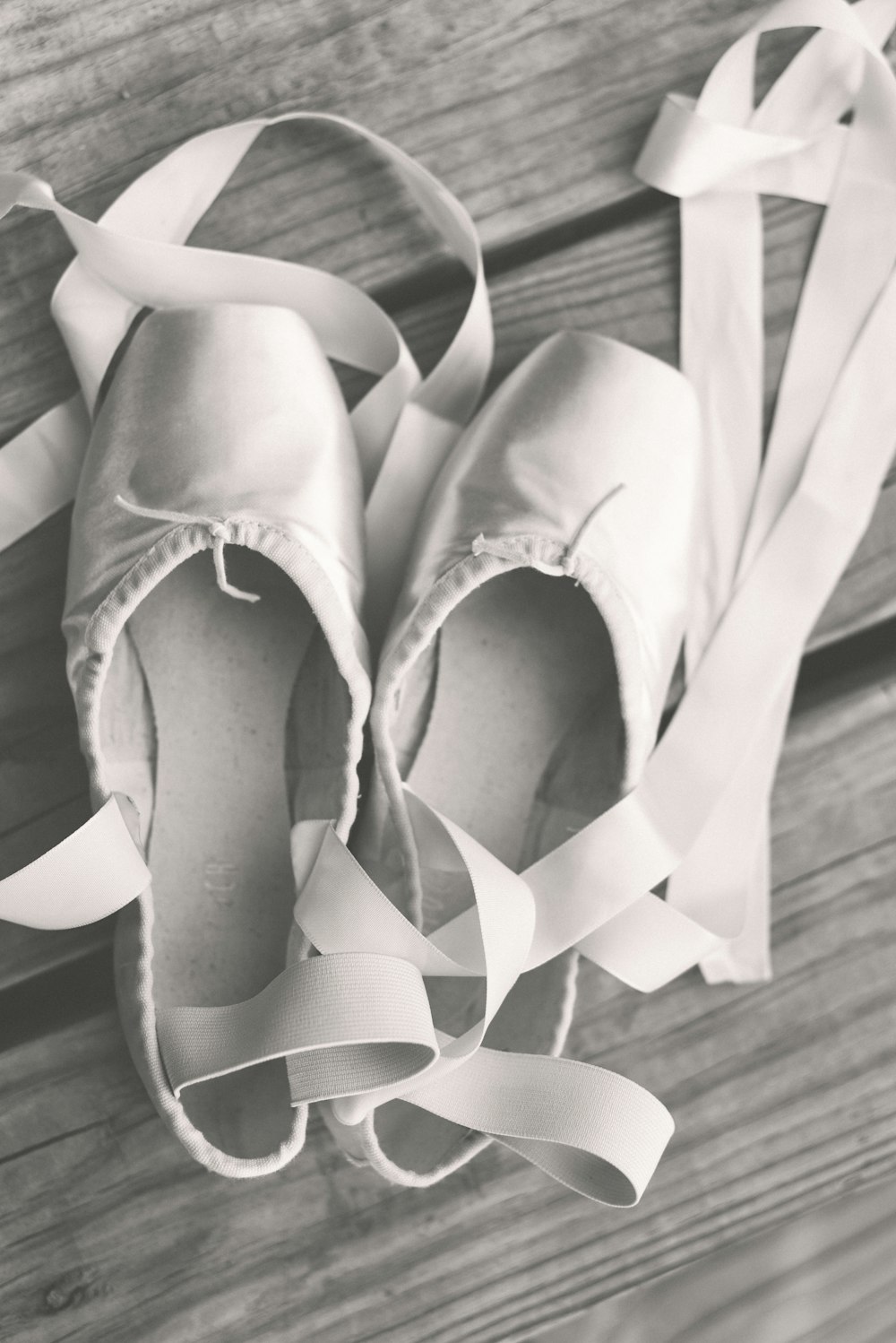 a pair of ballet shoes sitting on top of a wooden floor