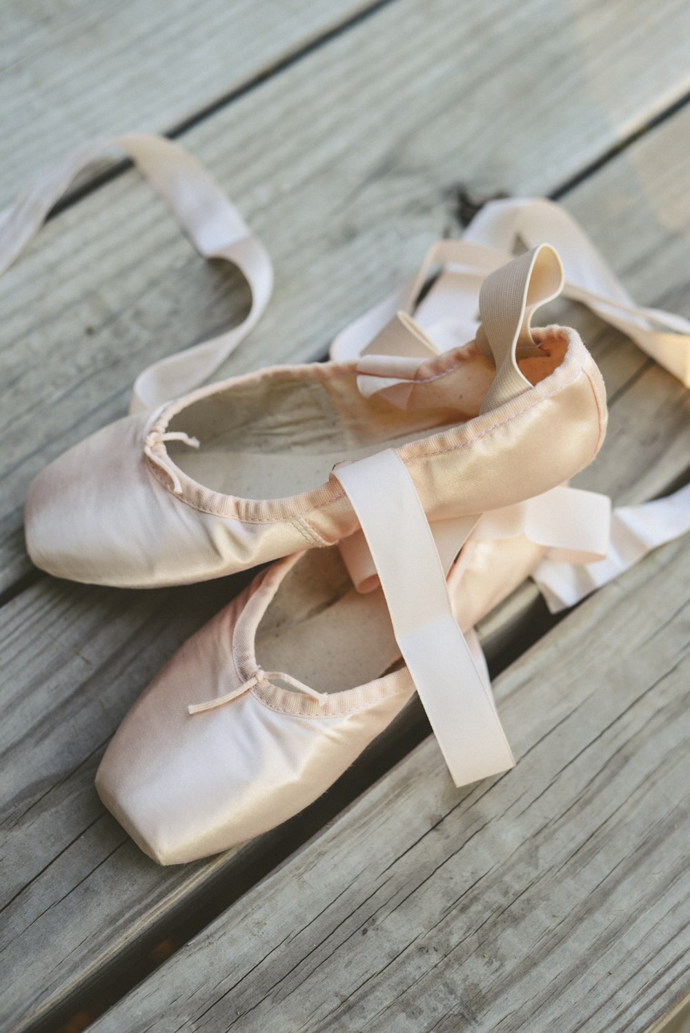 a pair of ballet shoes sitting on top of a wooden floor