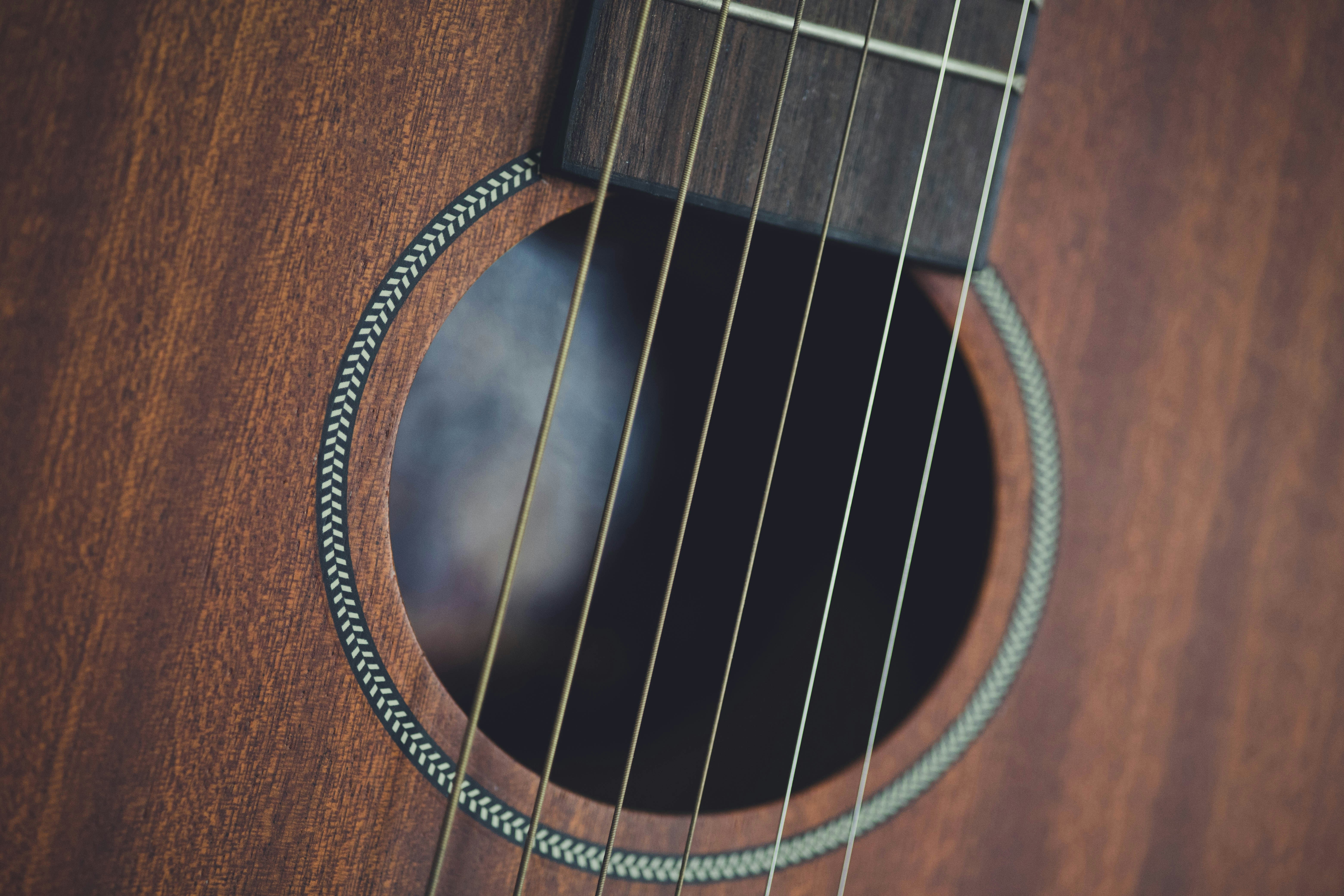 a close up of a guitar strings on a wooden guitar