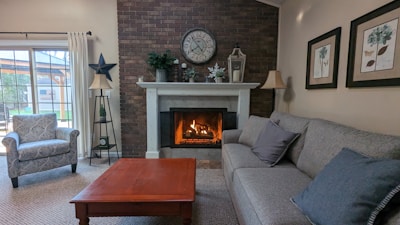 A cozy living room featuring a stylish wall clock and warm lighting.