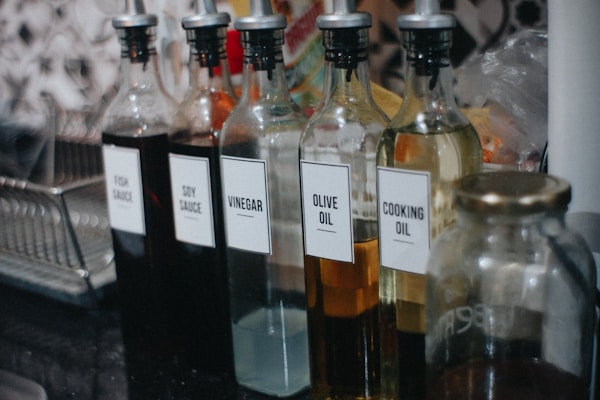 A row of bottles with labels on them sitting on a counter
