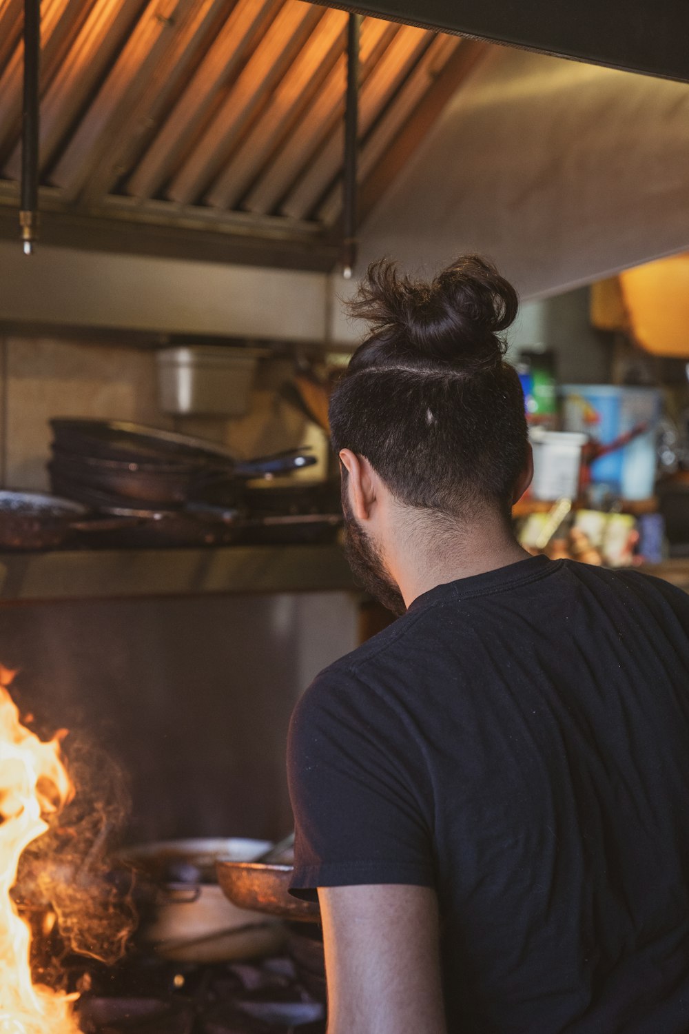 a man standing in front of a fire in a kitchen