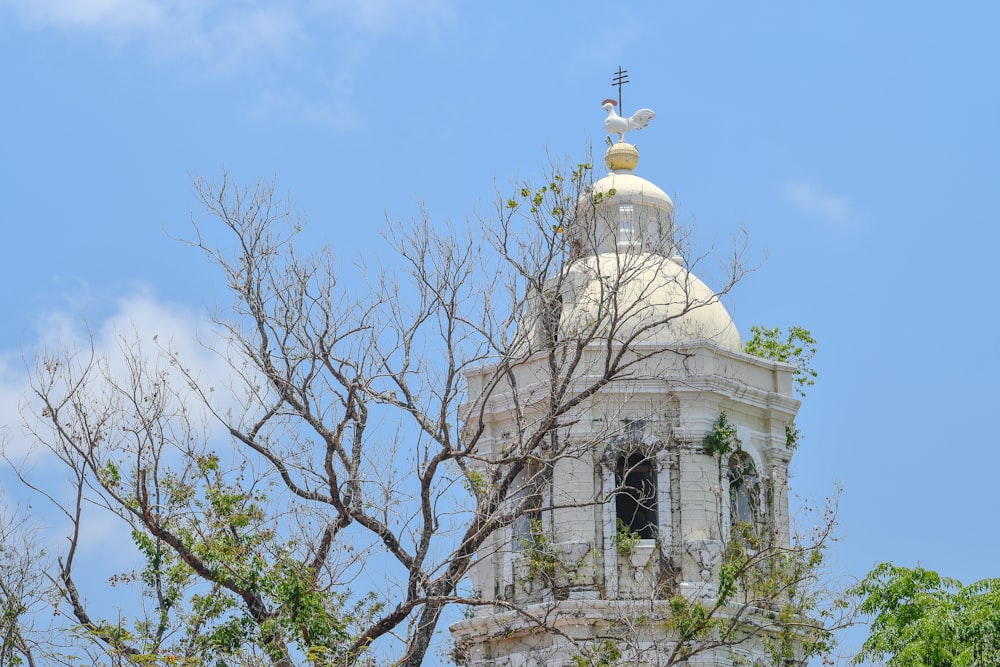 a tower with a clock and a weather vane on top of it