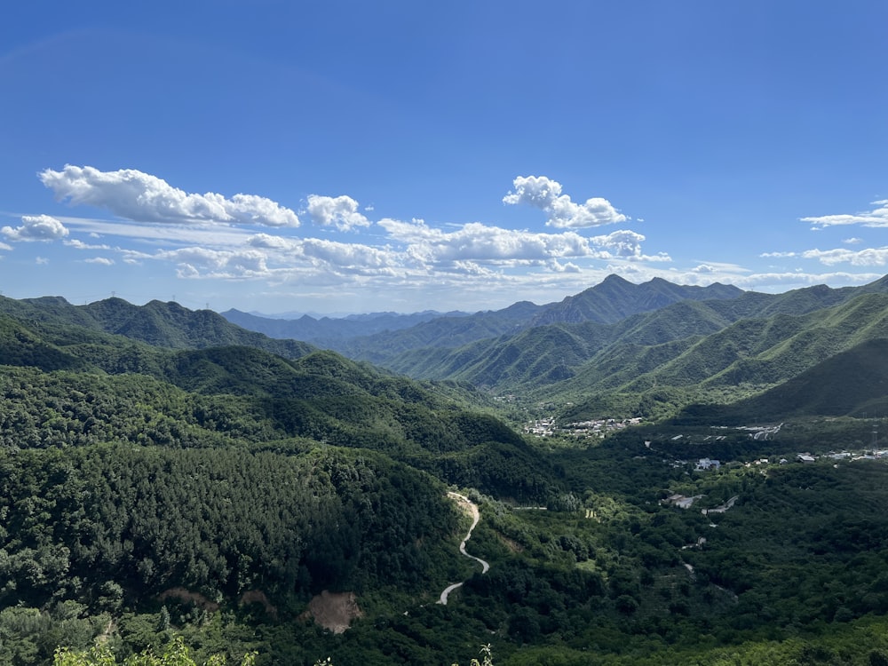 a scenic view of a valley with mountains in the background