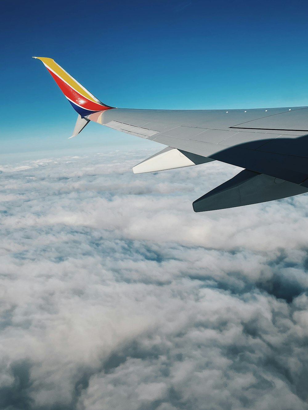 a view of the wing of an airplane above the clouds