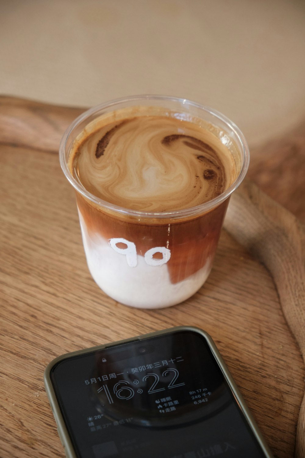 a cup of coffee next to a cell phone