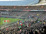 A packed stadium with fans waving red and white scarves during a thrilling Europa League match.