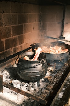 A warm kitchen scene with a cast iron pot simmering over a gentle flame, surrounded by fresh ingredients.