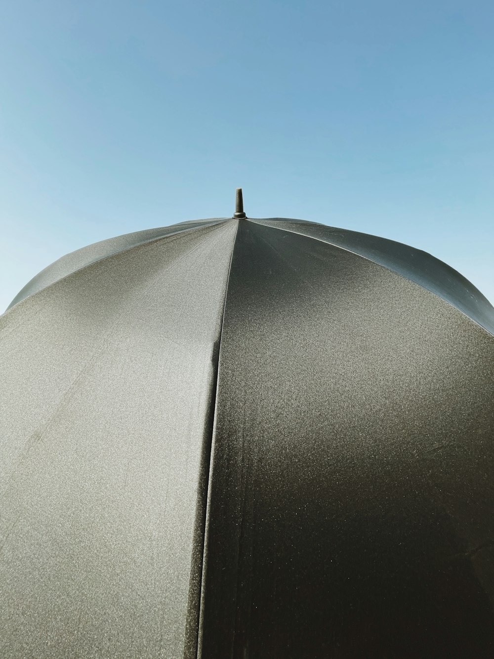 a black umbrella with a blue sky in the background