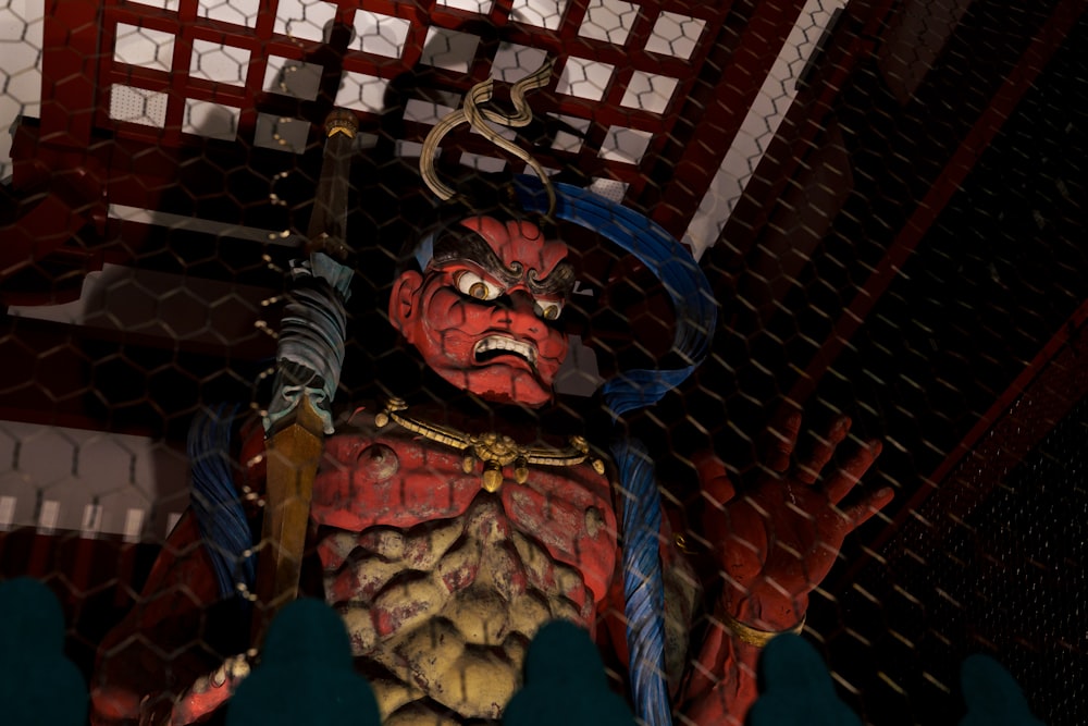 a statue of a demon in a caged area