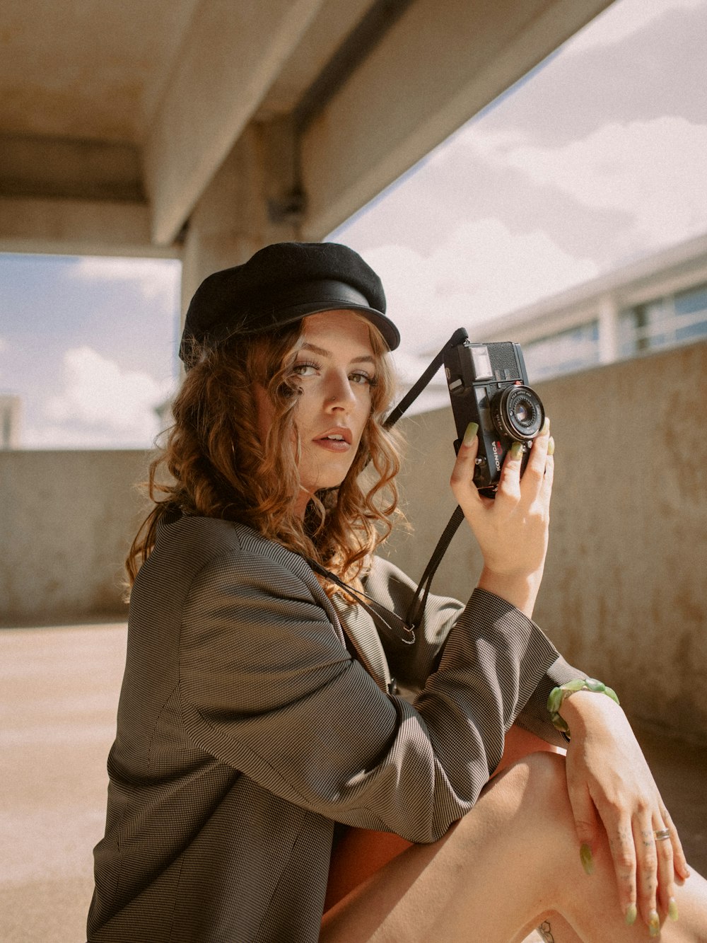 a woman sitting on the ground holding a camera