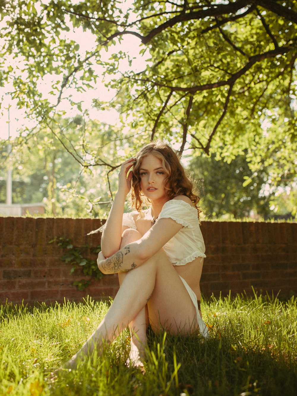 a woman sitting in the grass posing for a picture