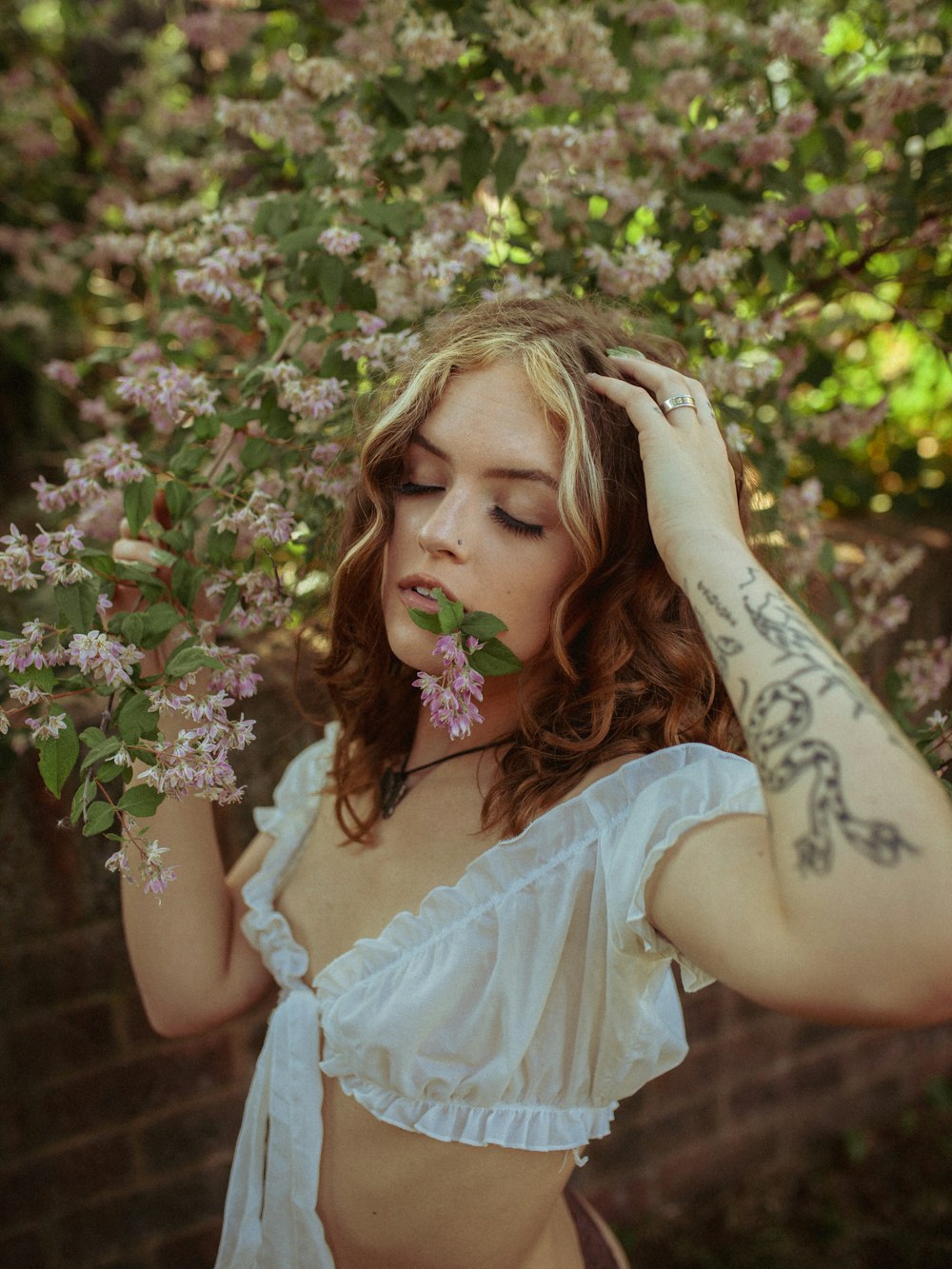 a woman in a white top holding a flower