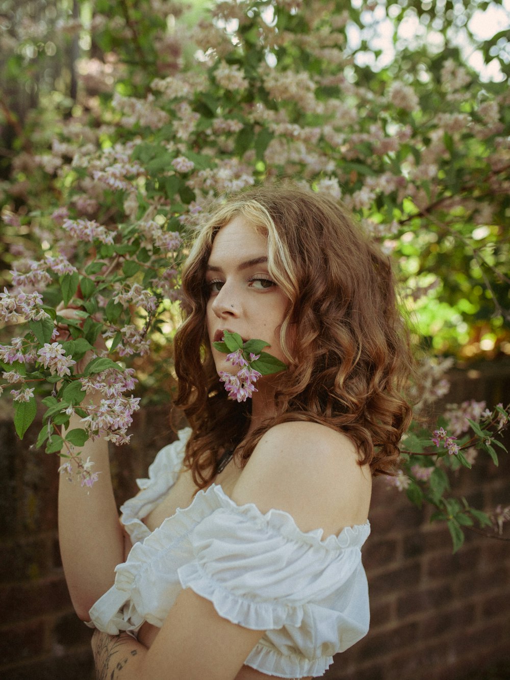 a woman in a white dress holding a flower