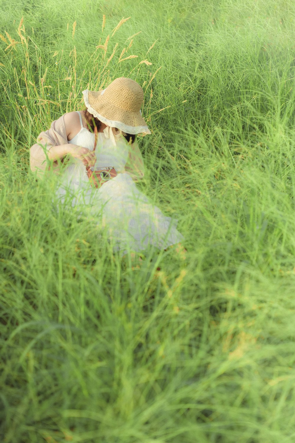 a woman sitting in a field of tall grass