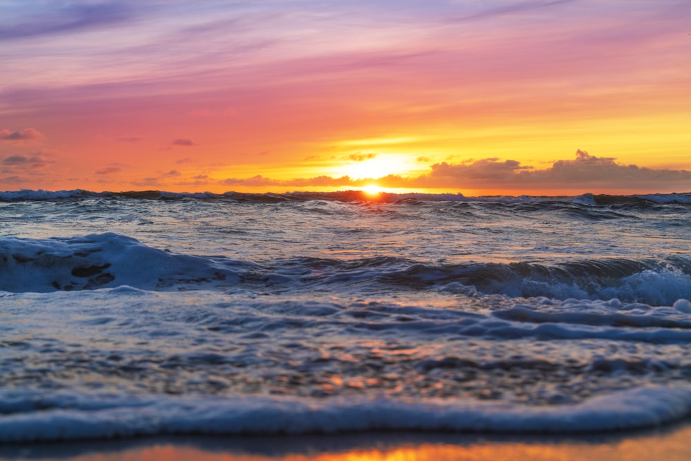 El sol se está poniendo sobre las olas del océano