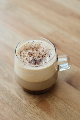 A vibrant mug with a steaming cappuccino topped with cinnamon powder.