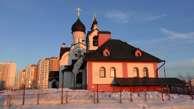 A peaceful view of St. Thomas Syriac Orthodox Church bathed in warm sunlight.